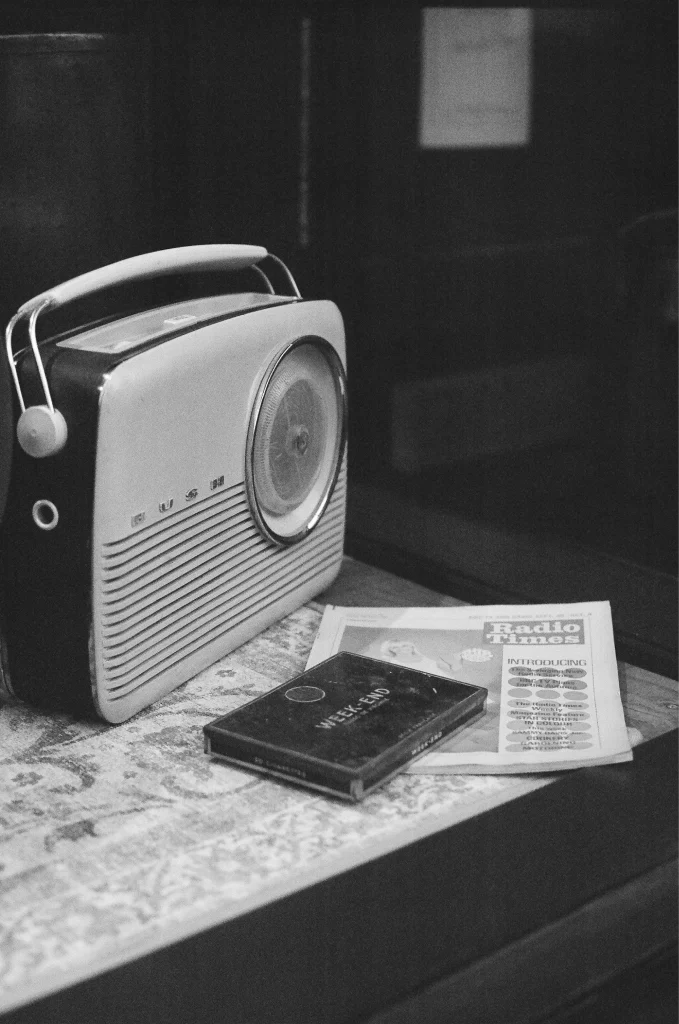 masa üzerindeki eski radyo ve radyo dergisinin siyah beyaz fotoğrafı